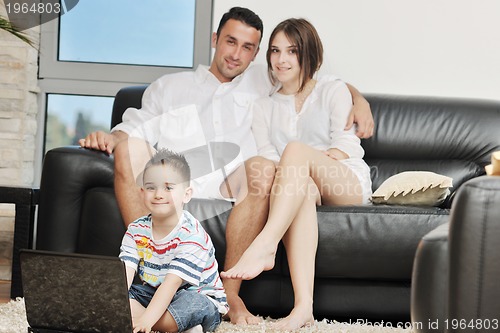 Image of happy young family have fun and working on laptop at home