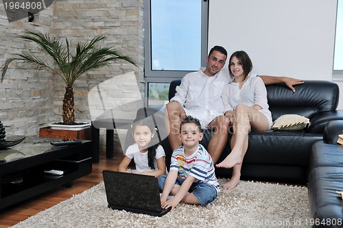 Image of happy young family have fun and working on laptop at home