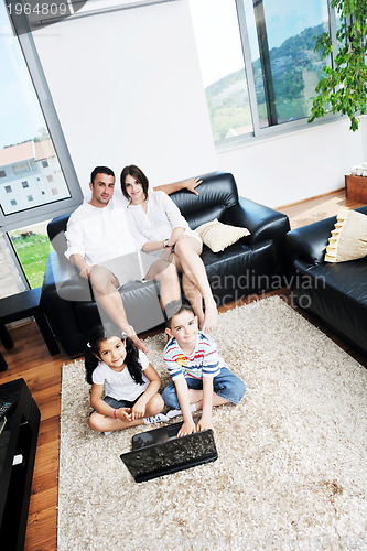 Image of happy young family have fun and working on laptop at home