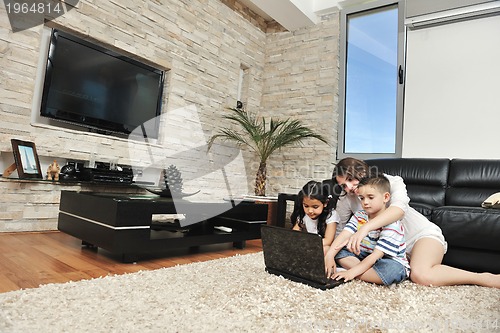 Image of happy young family have fun and working on laptop at home