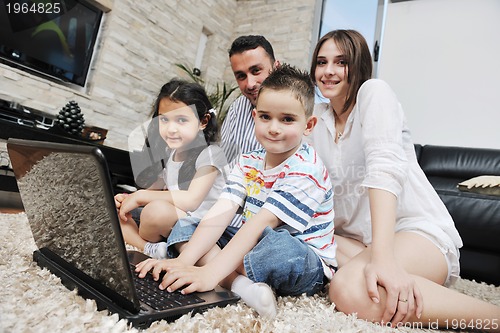 Image of happy young family have fun and working on laptop at home