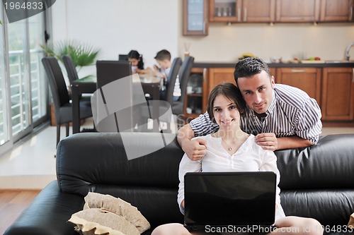 Image of happy young family have fun and working on laptop at home