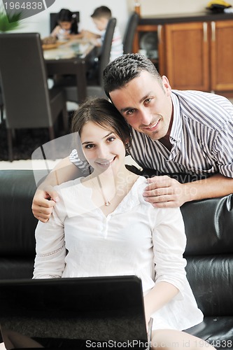 Image of happy young family have fun and working on laptop at home