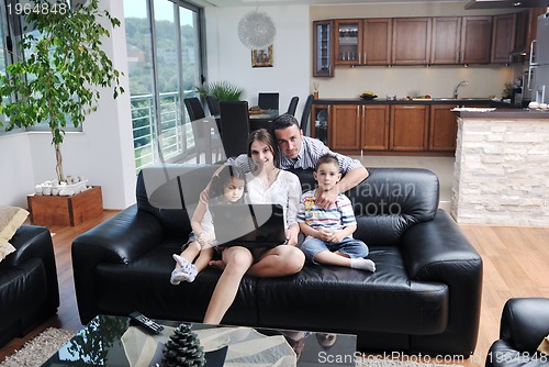 Image of happy young family have fun and working on laptop at home
