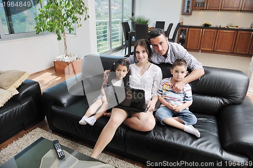 Image of happy young family have fun and working on laptop at home