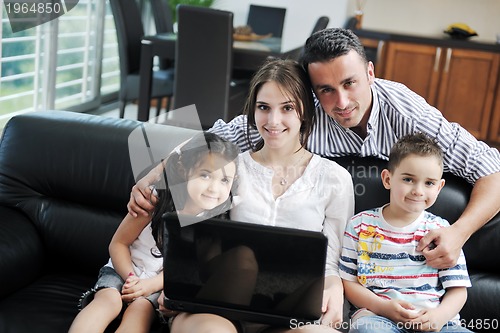 Image of happy young family have fun and working on laptop at home