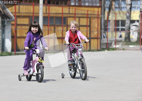 Image of happy childrens group learning to drive bicycle