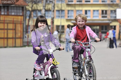 Image of happy childrens group learning to drive bicycle