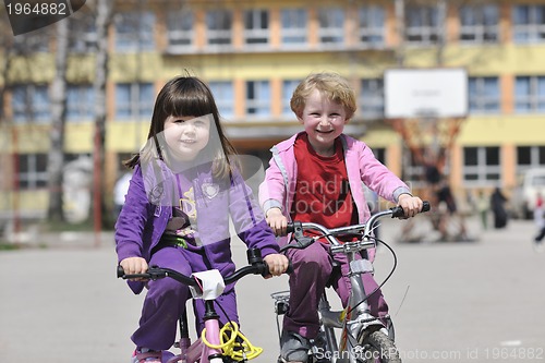 Image of happy childrens group learning to drive bicycle