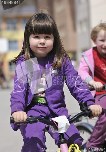 Image of happy childrens group learning to drive bicycle