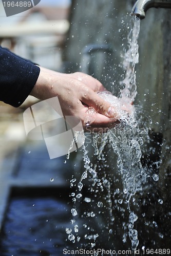 Image of fresh mountain water falling on hands