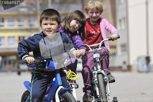 Image of happy childrens group learning to drive bicycle