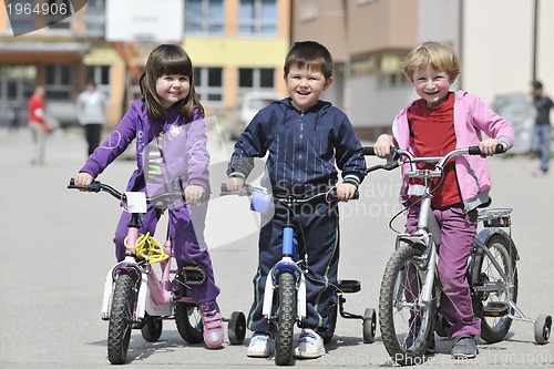 Image of happy childrens group learning to drive bicycle