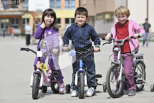 Image of happy childrens group learning to drive bicycle