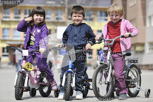 Image of happy childrens group learning to drive bicycle