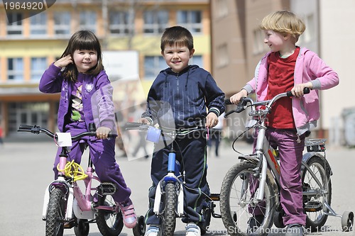 Image of happy childrens group learning to drive bicycle