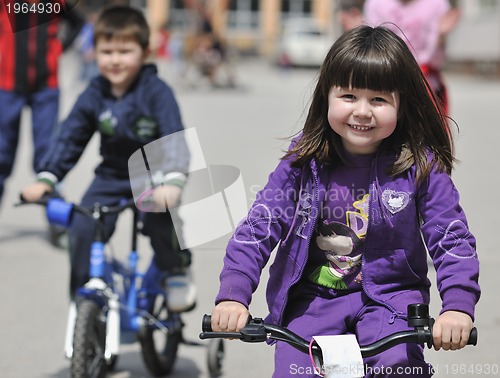 Image of happy childrens group learning to drive bicycle