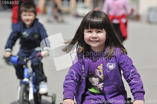 Image of happy childrens group learning to drive bicycle