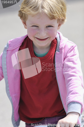 Image of cute little girl driving bicyle at sunny day