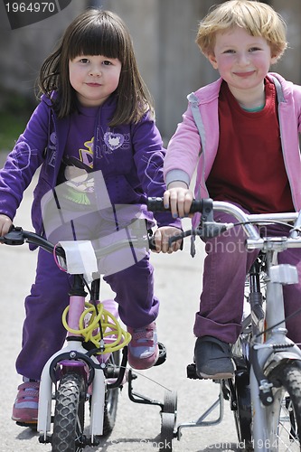 Image of happy childrens group learning to drive bicycle