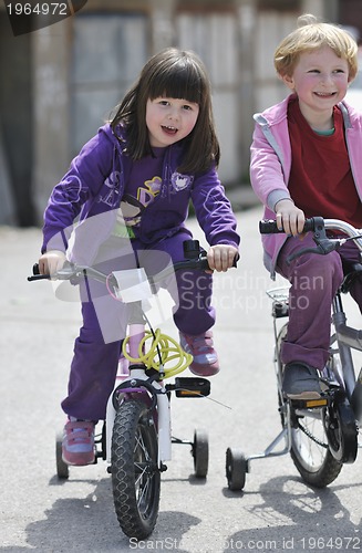 Image of happy childrens group learning to drive bicycle