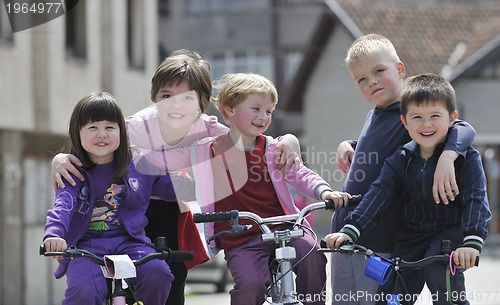 Image of happy childrens group learning to drive bicycle