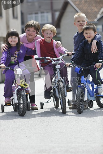 Image of happy childrens group learning to drive bicycle