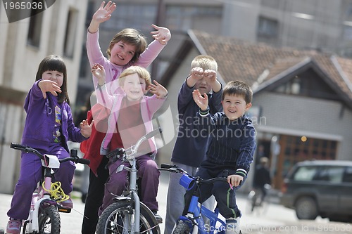 Image of happy childrens group learning to drive bicycle