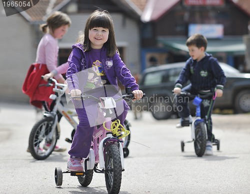 Image of happy childrens group learning to drive bicycle