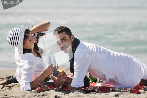 Image of young couple enjoying  picnic on the beach