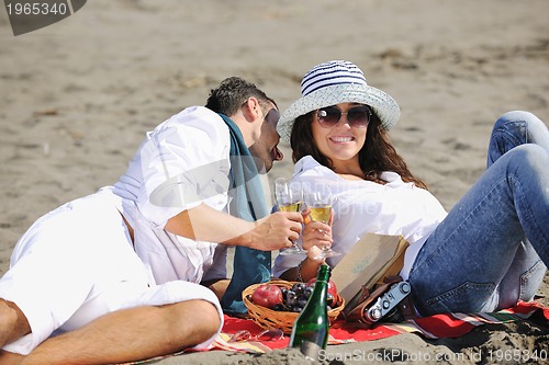 Image of young couple enjoying  picnic on the beach