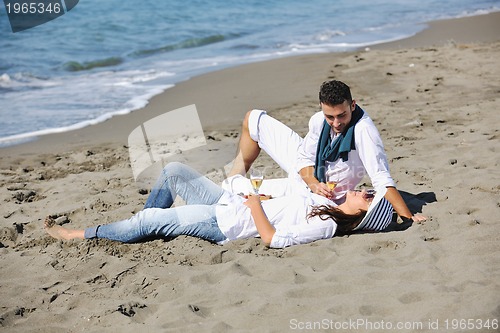 Image of young couple enjoying  picnic on the beach