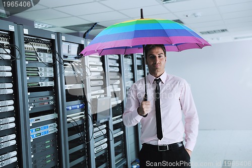 Image of businessman hold umbrella in server room