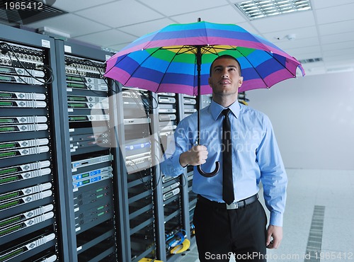 Image of businessman hold umbrella in server room