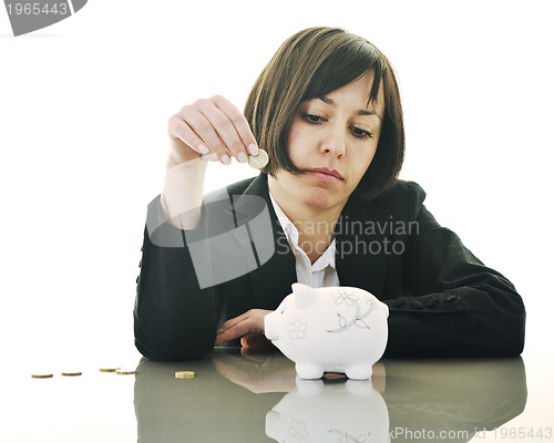 Image of business woman putting coins money in piggy bank