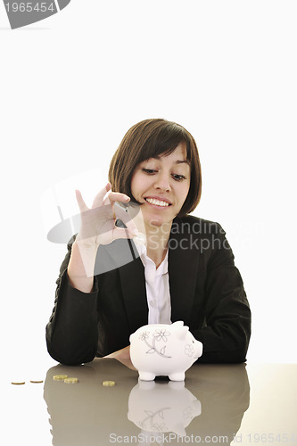 Image of business woman putting coins money in piggy bank
