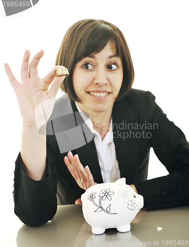 Image of business woman putting coins money in piggy bank