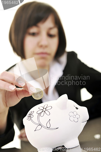 Image of business woman putting coins money in piggy bank