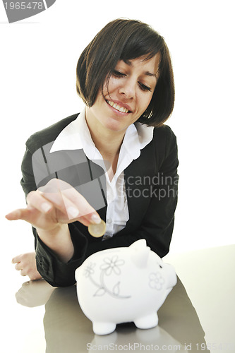 Image of business woman putting coins money in piggy bank