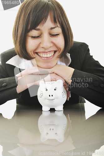 Image of business woman putting coins money in piggy bank