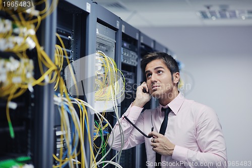 Image of it engeneer talking by phone at network room