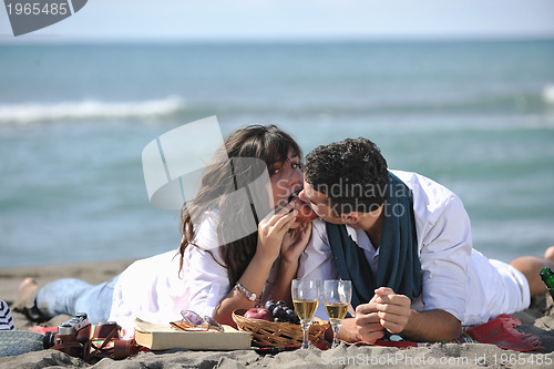 Image of young couple enjoying  picnic on the beach