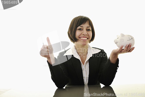 Image of business woman putting coins money in piggy bank