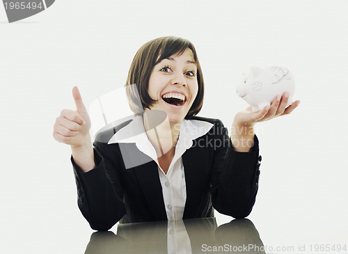 Image of business woman putting coins money in piggy bank