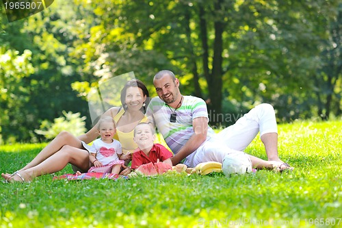 Image of happy young couple with their children have fun at park