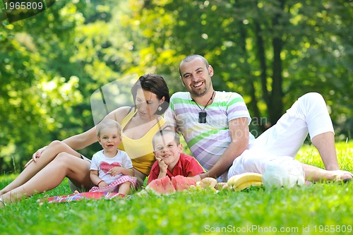 Image of happy young couple with their children have fun at park
