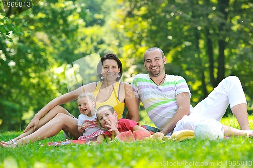 Image of happy young couple with their children have fun at park