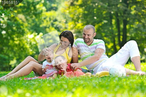 Image of happy young couple with their children have fun at park