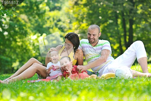 Image of happy young couple with their children have fun at park