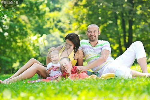 Image of happy young couple with their children have fun at park